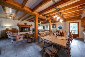 a dining room and living room with a wooden ceiling at La Gravière in La Salle-les-Alpes