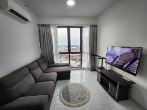 a living room with a couch and a flat screen tv at One Bedroom Troika Kota Bharu by AGhome in Kota Bharu