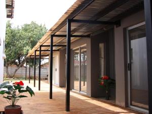 a building with glass doors on a wooden deck at Blesbok Inn in Polokwane