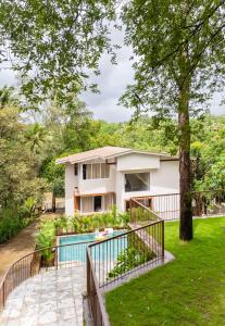 a house with a swimming pool and a yard at LohonoStays Villa Athini in Chinchavli