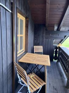 a wooden table and chairs on the porch of a cabin at Ferienwohnung Kohl - Dachlmoos in Bischofswiesen