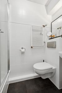 uma casa de banho branca com um WC e um chuveiro em E&K Apartment Kahrstraße em Essen