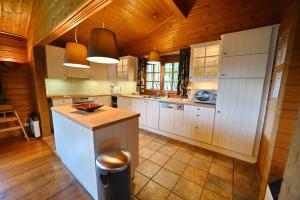 バルヴォーにあるGite Kleine Beerの白いキャビネットと木製の天井が備わるキッチン