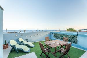 a patio with a table and chairs and the beach at San Borondón Sunset Apartment in Puertito de Güímar