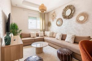 a living room with a couch and a table and mirrors at TT Holidays Cosy Apartment Hassan in Rabat