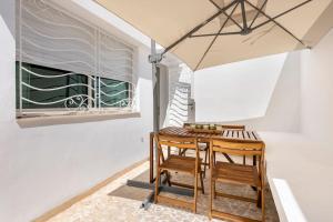 einen Tisch mit 2 Stühlen und einem Sonnenschirm in der Unterkunft TT Holidays Cosy Apartment Hassan in Rabat