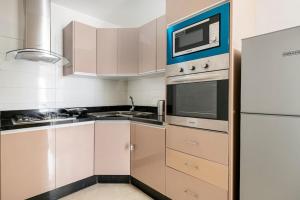 a kitchen with white cabinets and a microwave at TT Holidays Cosy Apartment Hassan in Rabat