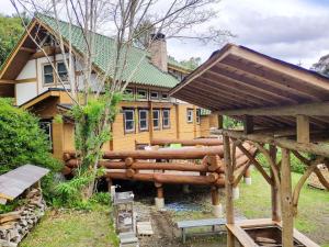 a log house with a wooden structure in front of it at Shimanologhouse - Vacation STAY 41662v in Iki