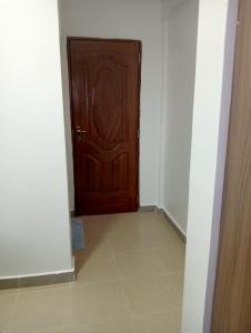 a hallway with a wooden door and a tile floor at Amalya suites by TJ3 in Eldoret