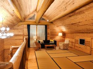 a living room with wooden walls and a ceiling with beams at Shimanologhouse - Vacation STAY 41662v in Iki