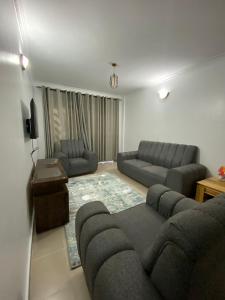 ein Wohnzimmer mit 2 Sofas und einem Sofa in der Unterkunft Amalya suites by TJ3 in Eldoret