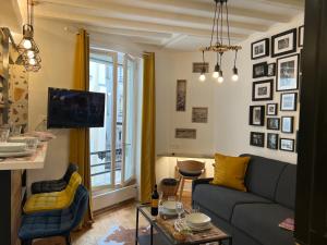 ein Wohnzimmer mit einem Sofa und einem Tisch in der Unterkunft Appartement Montmartre Sacré Cœur in Paris