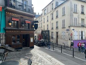 una calle de la ciudad con edificios y gente caminando por la calle en Appartement Montmartre Sacré Cœur, en París