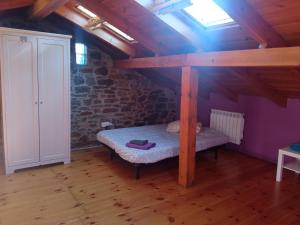 a room with a bed in a attic with a window at Casa típica asturiana en Ribota in Celleruelo