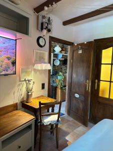 a room with a table and a desk with a chair at La Remise - Les Chambres in Neufchâteau