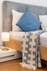 - un lit avec un oreiller bleu et une lampe sur une table de nuit dans l'établissement Apartment with Balcony near Augarten, à Vienne