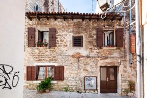 ロヴィニにあるApartman Paulinaの茶褐色の襟付きの古い石造りの建物