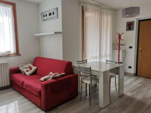 sala de estar con sofá rojo y mesa en Bomboniera Milano zona RHO FIERA - Bilocale 70mq, en Senago