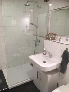 a white bathroom with a sink and a shower at Ferienwohnung Kofferfisch in Sierksdorf +2 photos
