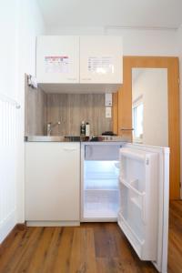 a kitchen with an open refrigerator and a sink at Montfort Apartments - Feldkirch in Feldkirch