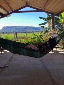 a woman laying in a hammock under a roof at Pousada do Nondas in Estivado