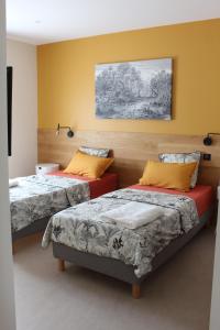 a bedroom with two beds and a painting on the wall at Villa plain pied vue terrasse in Port-Vendres