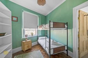 a bedroom with green walls and bunk beds in it at 3 Bed - Admiralty Retreat by Pureserviced in Plymouth