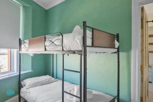 two bunk beds in a room with a green wall at 3 Bed - Admiralty Retreat by Pureserviced in Plymouth