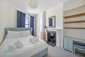 a bedroom with a blue bed and a fireplace at 3 Bed - Admiralty Retreat by Pureserviced in Plymouth