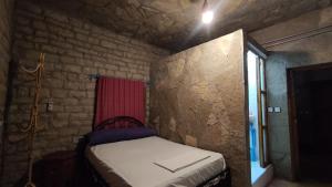 a small room with a bed in a brick wall at Maison La lune des gorges in Tinerhir