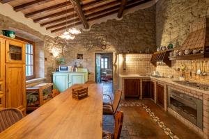 eine große Küche mit einem Holztisch in einem Zimmer in der Unterkunft Podere Ostoncino in Chianni