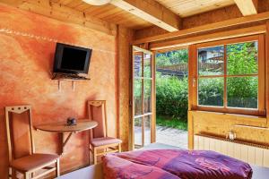 a bedroom with a bed and a table and a tv at Trucks Hütte in Mayrhofen