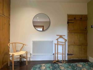 a room with a mirror and a chair and a radiator at Cosy Cottage (Free parking) in Macclesfield