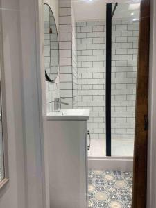 a bathroom with a sink and a mirror and a shower at Cosy Cottage (Free parking) in Macclesfield
