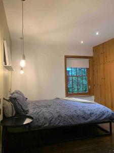 Schlafzimmer mit einem Bett, einem Tisch und einem Fenster in der Unterkunft Cosy Cottage (Free parking) in Macclesfield