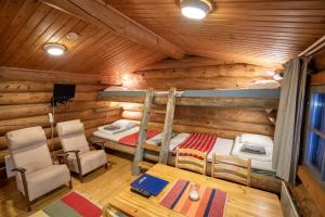 - une chambre dans une cabane en rondins avec un lit et une table dans l'établissement Fell Centre Kiilopää, Hotelli Niilanpää, à Saariselka
