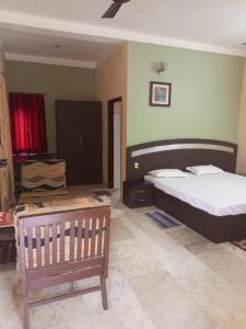 a bedroom with a bed and a bench in it at MADHUR RESIDENCY in Puri