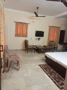 a living room with a bed and a table and chairs at MADHUR RESIDENCY in Puri +12 photos