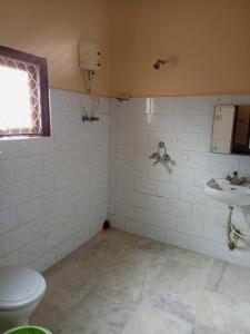 a bathroom with a toilet and a sink at MADHUR RESIDENCY in Puri