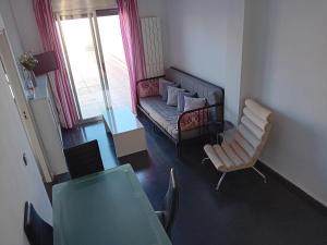 ein Wohnzimmer mit einem Sofa und einem Stuhl in der Unterkunft Apartamentos Turísticos Los Ángeles in Alcázar de San Juan