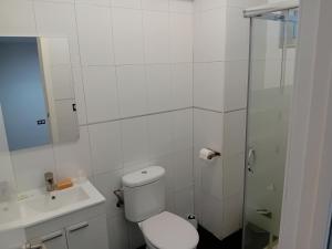a white bathroom with a toilet and a shower at Apartamentos Turísticos Los Ángeles in Alcazar de San Juan