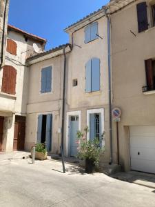 a large building with blue doors and a garage at Maison au cœur de la Ville. in Saint-Gilles
