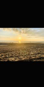 a beach with the sun setting in the horizon at Zentrale Altstadtkoje für bis zu 6 Personen in Neustadt in Holstein