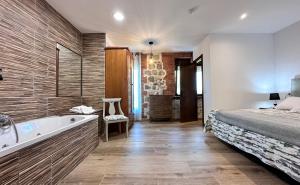 1 dormitorio con 1 cama y bañera junto a la cama en Apartamentos Rurales Sobremazas, en Sobremazas
