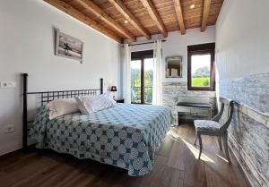a bedroom with a bed and a table and a chair at Apartamentos Rurales Sobremazas in Sobremazas