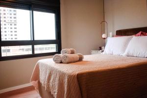 ein Schlafzimmer mit einem Bett mit zwei Handtüchern darauf in der Unterkunft Apartamento no Parque Una com vista espetacular in Pelotas