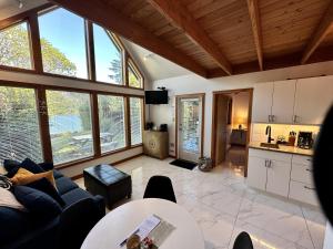 een woonkamer met een bank en een tafel bij Beautiful Oceanfront Cabin With Hot Tub! - Gone With The Wind in Ucluelet