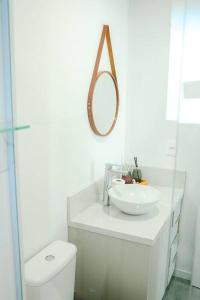 ein weißes Bad mit einem Waschbecken und einem WC in der Unterkunft Apartamento no Parque Una com vista espetacular in Pelotas