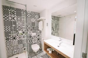a bathroom with a black and white tiled wall at Utopia Hotel - Art & Nature Hotel in Mons