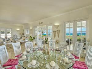 a dining room with a glass table and chairs at Larimar - Luxury Ocean Front Villa in Saint Philip